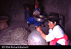 potter working while dry clay is sifted in background